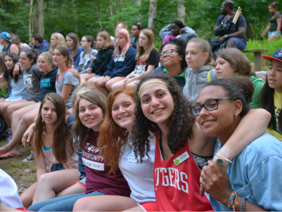 A crowd of people sitting together, smiling.